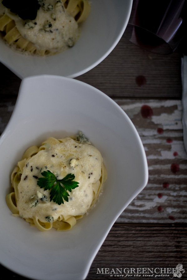 Pasta Alfredo in white bowls o a wooden background