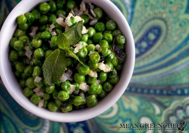 Minted Peas with Lemon and Shallots in a white bowl on a paisley background.