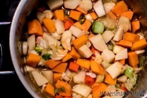 Ingredients cooking in a large stock pot on the stove top for Dutch Stamppot. Mean Green Chef