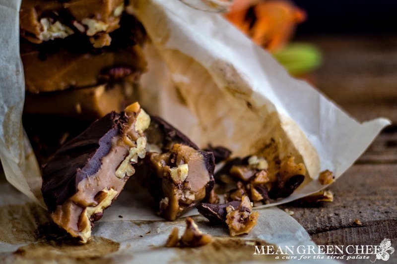Toffee stacked on white parchment paper on a rustic wooden background. Mean Green Chef