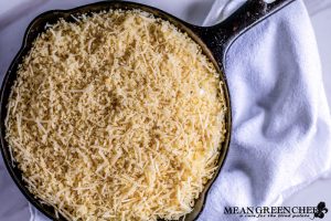 Overhead photo of Jalapeno Popper Dip in a cast iron pan sitting on a white cotton kitchen towel. Mean Green Chef