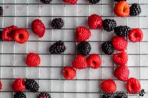 Sugared Blackberries and raspberries drying on a baking rack.