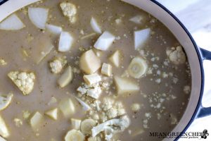 Creamy Cauliflower Bisque in large gray Dutch Oven ready to be cooked.