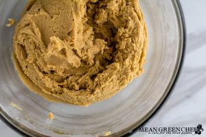 Ingredients for Best Ever Molasses Cookies brown and white sugar with eggs in a large glass bowl beaten together.