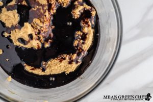 Ingredients for Best Ever Molasses Cookies brown and white sugar beaten with eggs and molasses in a large glass bowl.