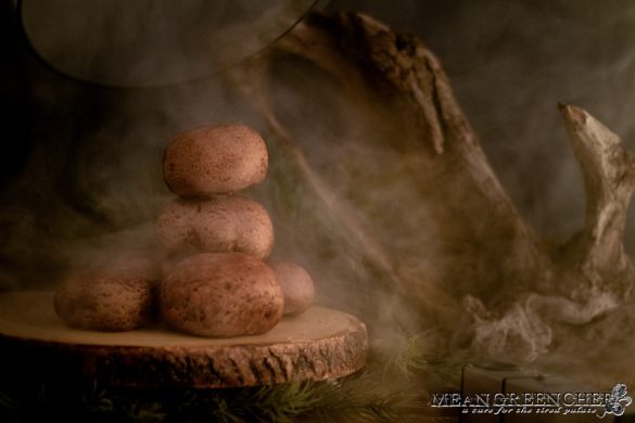 Portobello mushrooms smoking with bourbon wood under a glass dome that has just been lifted.