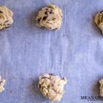 Bakery Style Chocolate Chip Cookie dough ready to be baked, sitting on a sheet pan lined with parchment paper.