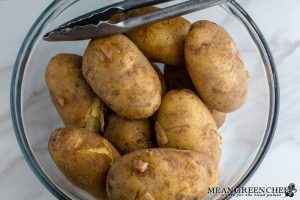 Boiled potatoes with skins starting to peel off for Irish Colcannon.