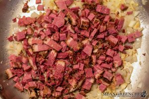 Overhead shot of Restaurant Style Corned Beef Hash cooking in a saute pan.