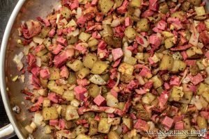 Overhead shot of Restaurant Style Corned Beef Hash cooking in a saute pan.