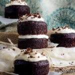 Side photo of Guinness Chocolate Cake with chocolate shavings sitting on parchment paper.