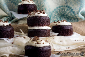 Side photo of Guinness Chocolate Cake with chocolate shavings sitting on parchment paper.