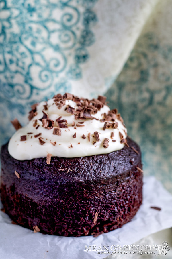 Side photo of Guinness Chocolate Cake with chocolate shavings sitting on parchment paper.