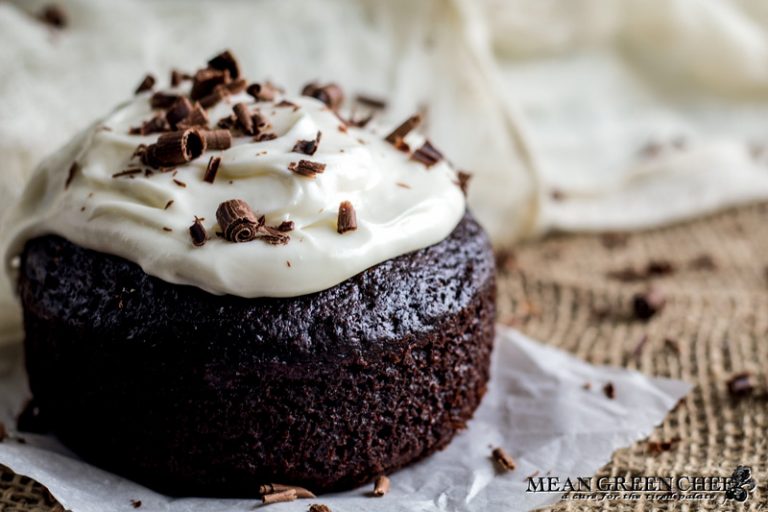 Side photo of Guinness Chocolate Cake with chocolate shavings sitting on parchment paper.