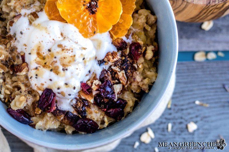 Overhead shot of a bowl of Spiced Mandarin Pecan Oatmeal garnished with whipped cream and Sumo Citrus.