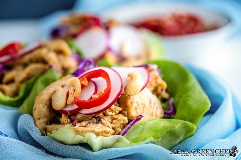 Thai Chicken Lettuce Wraps on a white background with Prik nam pla.