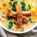 Bistro Broccoli Cheese Soup in large white bowls garnished with grilled sourdough bread.