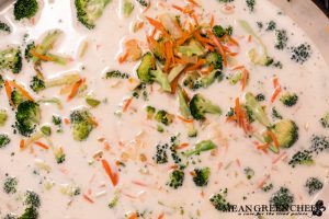 Bistro Broccoli Cheese Soup being made in a large gray Dutch Oven.