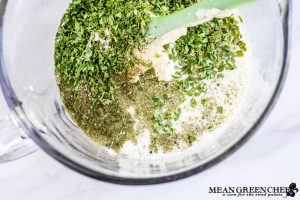 Herbed Buttermilk Ranch Dressing being mixed in a large glass bowl.