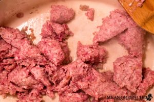 Country Sausage Gravy being made in a large gray Dutch Oven on the stove top.