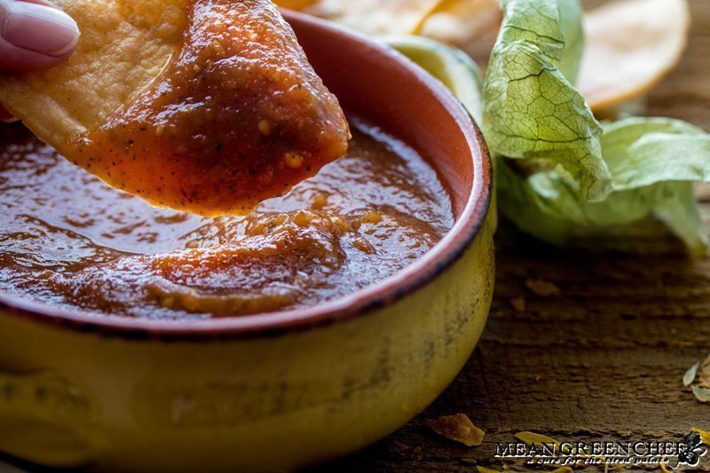 Restaurant Style Salsa in a yellow bowl with a freshly made tortilla chip being dipped.