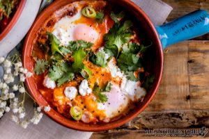 Shakshuka garnished with cilantro and goat cheese.