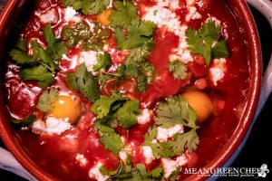 Shakshuka cooking in a clay pot.