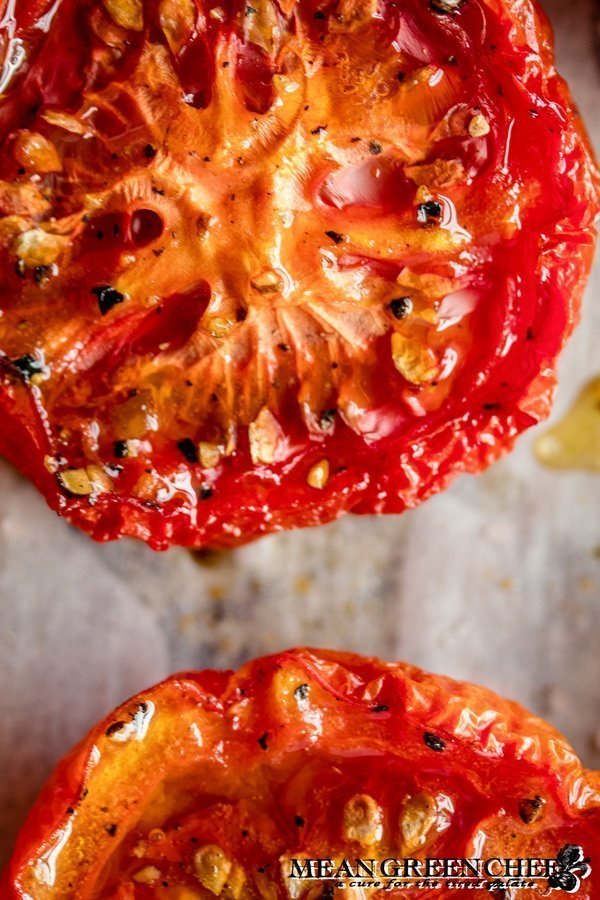 Close up of Sweet Slow Roasted Tomatoes on a sheet pan lined with parchment paper.