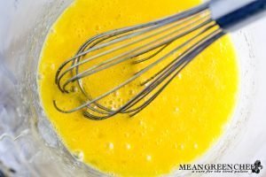 Eggs beat in a glass bowl for flan.