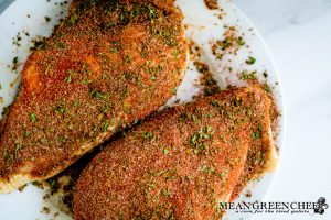 Blackened Chicken breasts with Badass Blackened Seasoning resting on a white plate.