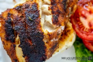 Closeup, Gulfside Blackened Grouper on a white plate with a ripe tomato slice and fresh romaine lettuce situated at the top of the plate.