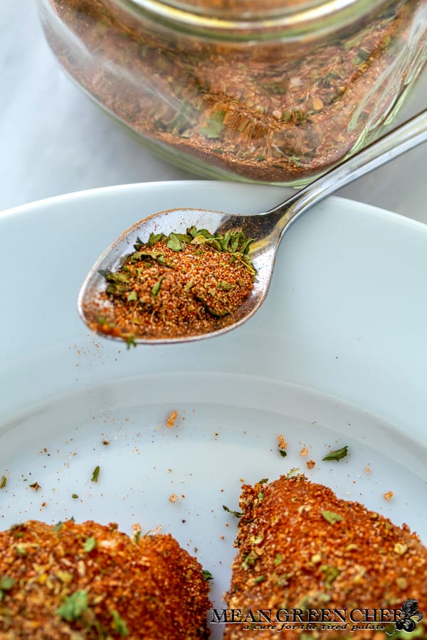 Gulfside Blackende Grouper being seasoned with Badass Blackened seasoning from a spoon.