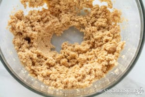 Meyer Lemon Cookie Dough in a glass bowl on a marble countertop, showing a creamy texture.