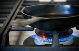 Cast iron pan being heated over an open flame.