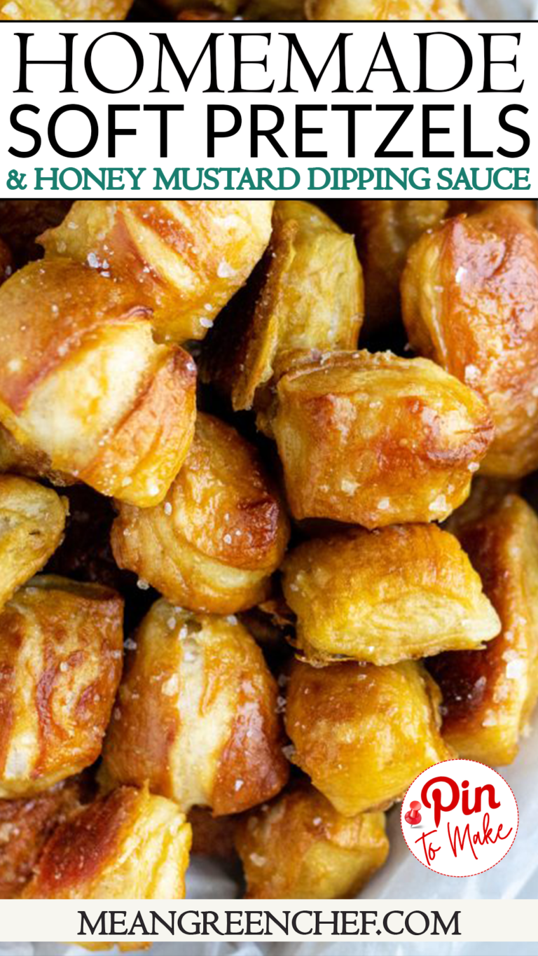 Close-up of golden brown pretzel bites in a white paper-lined bowl, accompanied by a cup of honey mustard sauce on the side, on a light textured surface.