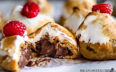 Rich Chocolate Creme Patissiere Pastry Cream in cream puffs with Swiss Meringue and red raspberries on top.