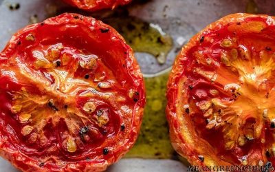 Close up of Sweet Slow Roasted Tomatoes on a sheet pan lined with parchment paper.