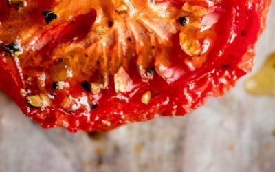 Close up of Sweet Slow Roasted Tomatoes on a sheet pan lined with parchment paper.